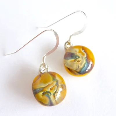 Yellow reactive glass earrings with a marble effect on top and 925 sterling silver ear hooks attached.