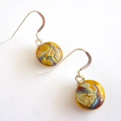 Different angle of yellow marble effect reactive glass earrings.