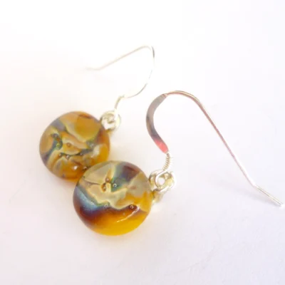 Side view of reactive glass earrings showing depth of glass.