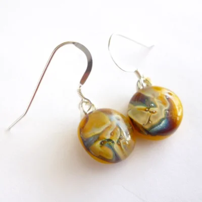 Yellow reactive glass earrings on a white background