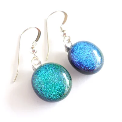 Side view of green dichroic glass earrings showing depth of glass.