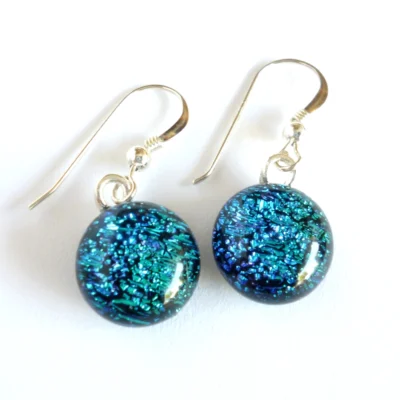 Blue dichroic glass earrings with each handmade round cabochon attached to silver plated bails and hang from 925 sterling silver ear hooks.