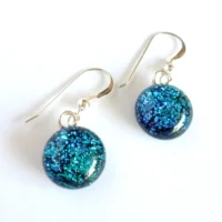 Teal blue dangle dichroic glass earrings with round handmade cabochons. Silver plated bails and sterling silver ear hooks attached.