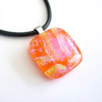 Handmade square dichroic glass pendant with pink and yellow/orange sparkle. Bail and cord attached.
