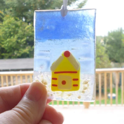 Small fused glass suncatcher being held at the bottom left corner
