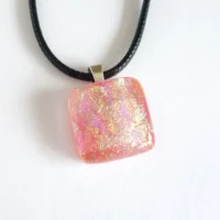Square handmade dichroic glass pendant with 925 sterling silver bail and black cord necklace. Pendant has shimmers of yellow and pink from the dichroic.