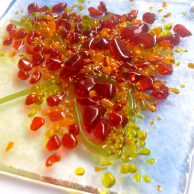 Close up of tactile red, orange and green glass, creating an autumn tree.
