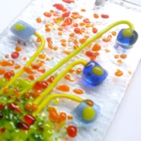 Close up of blue glass flower suncatcher showing tactile and depth of glass.