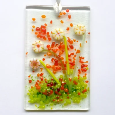 Small rectangle cream glass flower suncatcher with quirky cream flowers made with discs of glass. Orange and green frit for decoration.