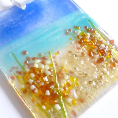 Close up of fused glass coastal suncatcher showing detail of glass