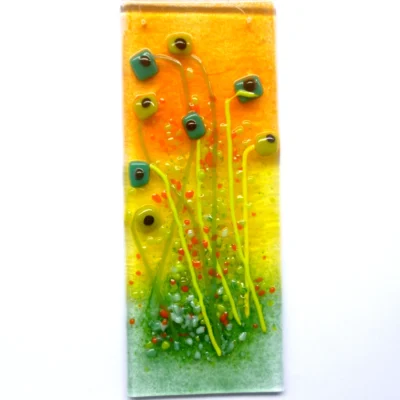 Fused glass floral suncatcher featuring quirky green square flowers on long stems with orange and green frit.
