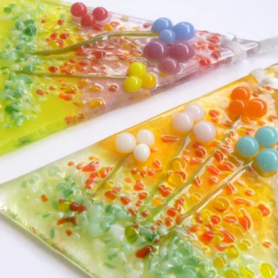 Close up of handmade glass flower suncatchers showing vibrant colours and tactile design.