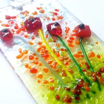 Close up of red glass flower suncatcher showing detail and depth of glass.