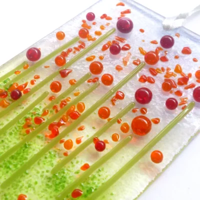Close up of red glass flower suncatcher showing detail and depth of class.