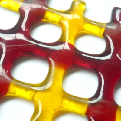 Close up of red and yellow lattice fused glass suncatcher showing smooth glass.
