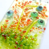 Close up of turquoise glass flower suncatcher showing tactile and detail of design
