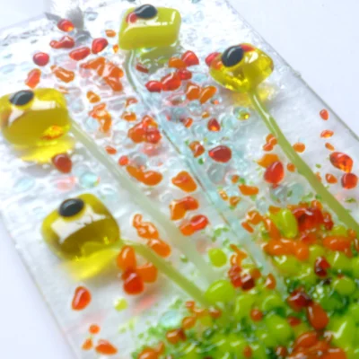 Close up of yellow fused glass flower suncatcher. Design showing detail and how tactile it is.